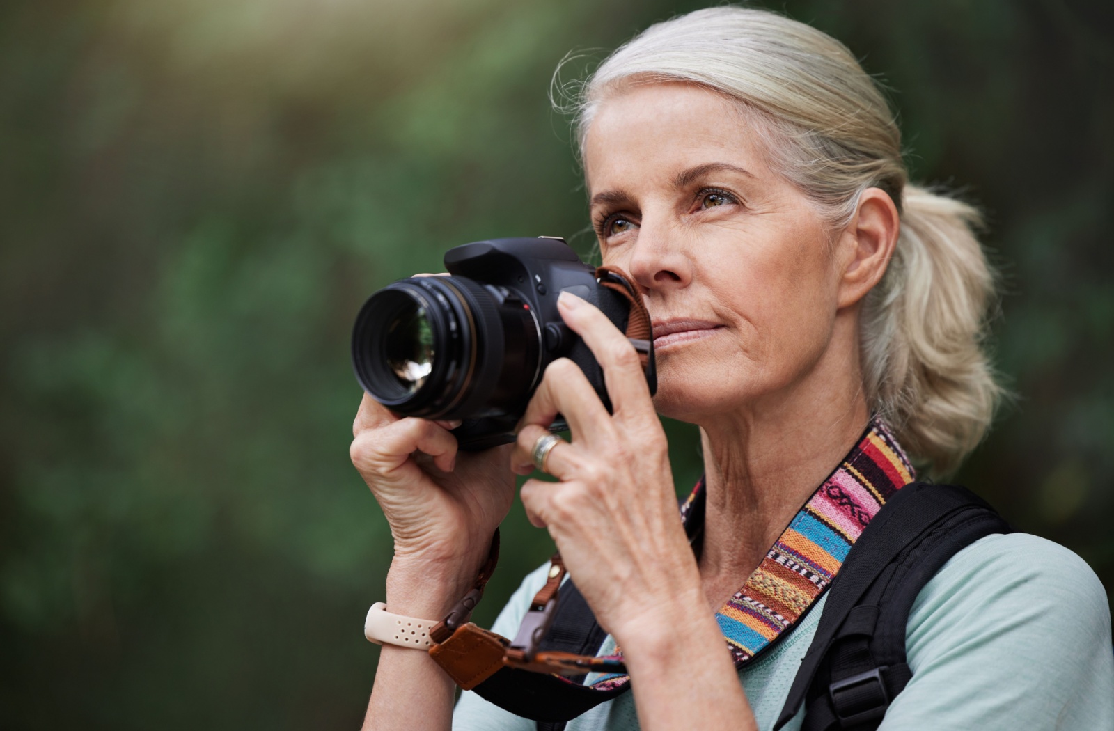 A senior woman takes photos with a DSLR camera