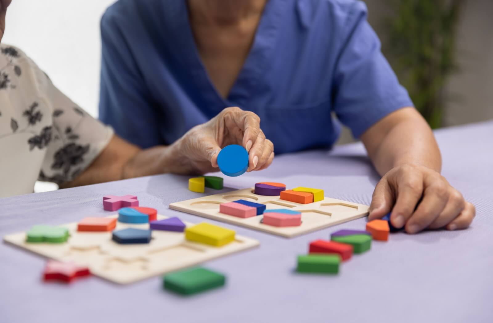 Older adult doing a puzzle activity with support