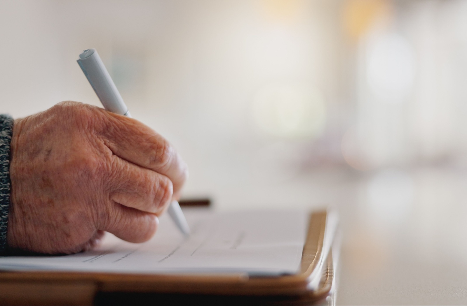 Close up of a senior writing in a journal.