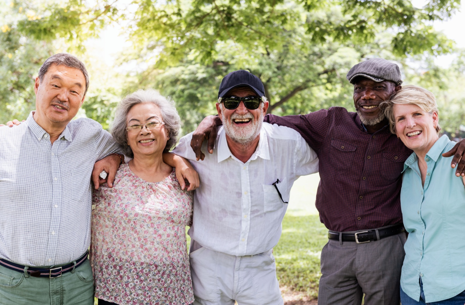 A group of senior friends with their arms around each other, smiling for the camera.