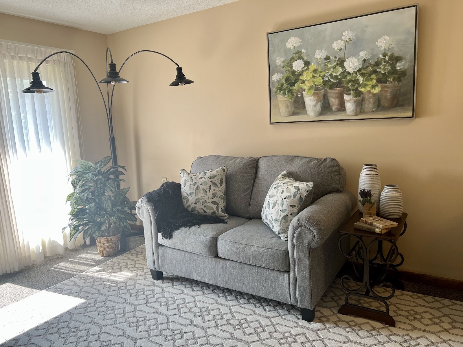 An assisted living room at Kingston Residence of Marion showing a couch, wall art, and a lamp.
