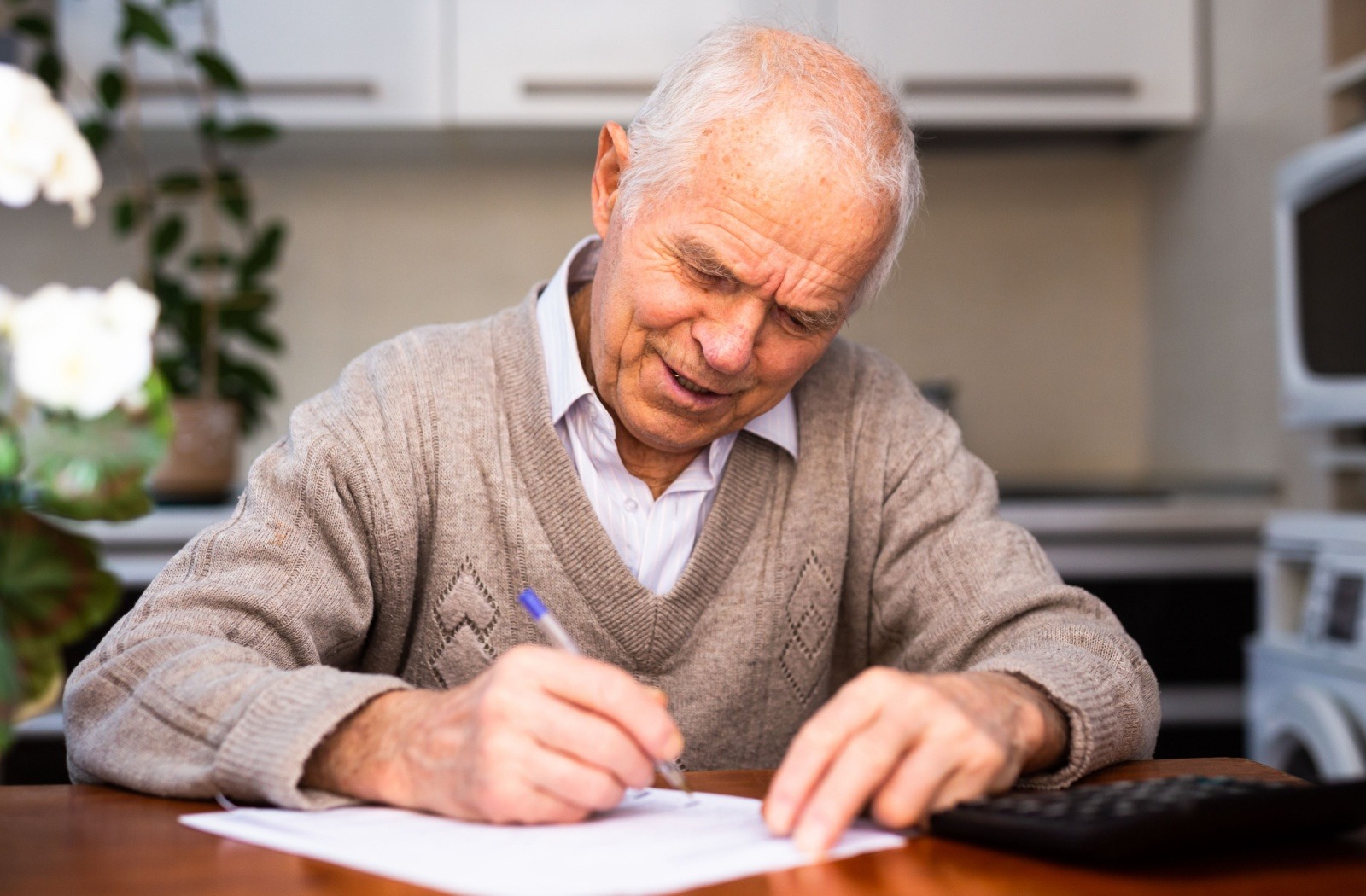 A senior sits at a desk and writes a journal entry.